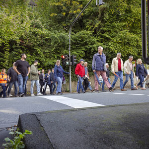 Die Teilnehmenden queren eine Straße über eine signalgesicherte Furt.