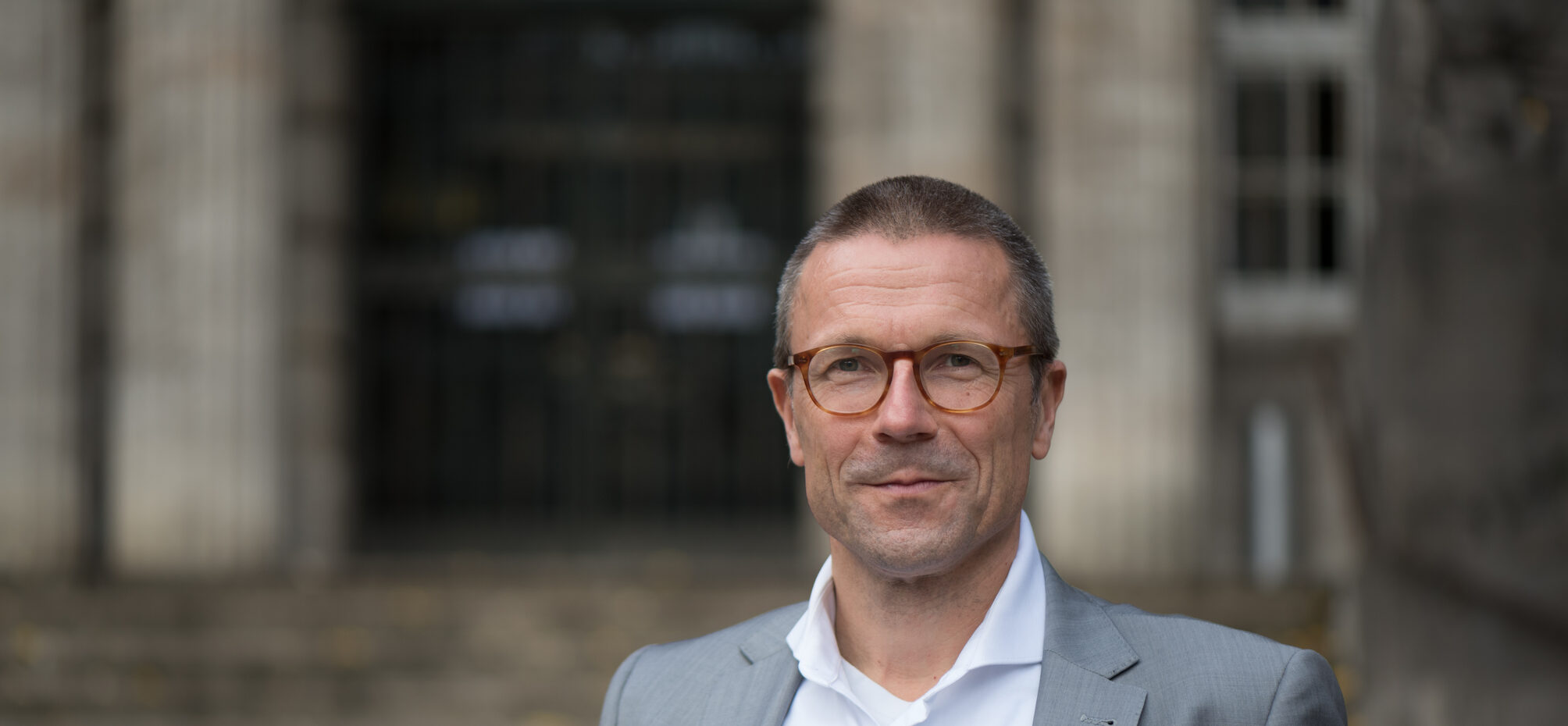 Portrait Oberbürgermeister Uwe Schneidewind vor den Rathaustreppen