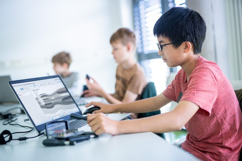 Schüler sitzt an Laptop