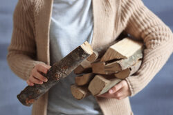 Woman holding pile of firewood, close up view