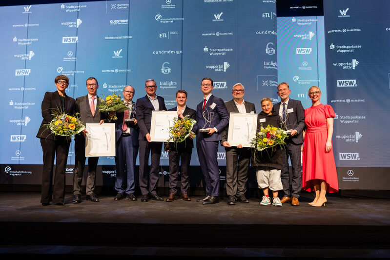 Gruppenbild der Preisträger mit Laudatoren, Veranstaltern und Moderatorin