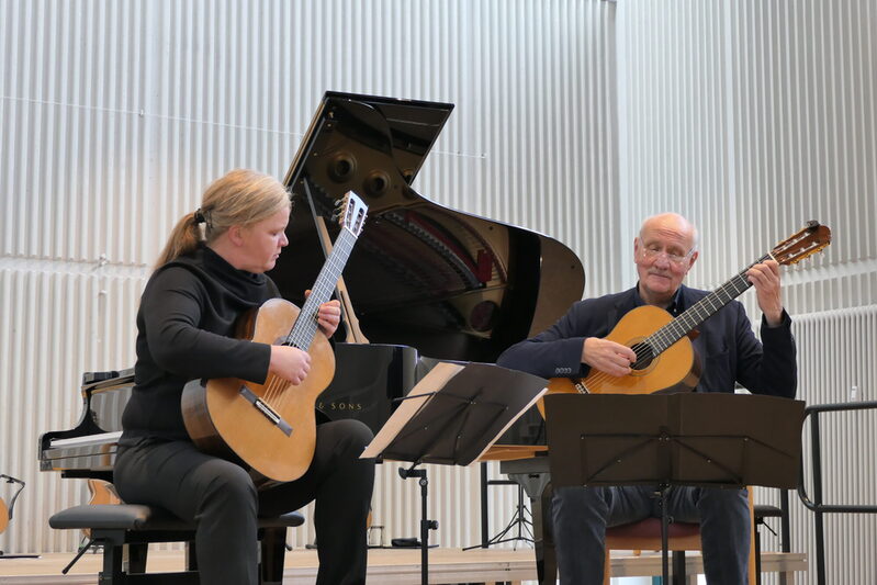 Corinna Schäfer (links) und Prof. Alfred Eickholt (rechts) spielen Gitarre