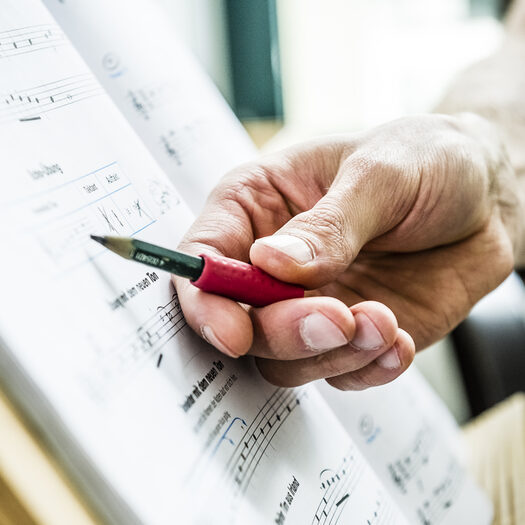 Hand deutet auf Noten