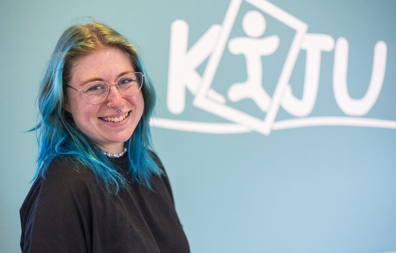 Bild von lächelnder Dame mit blauen Haaren und Brille