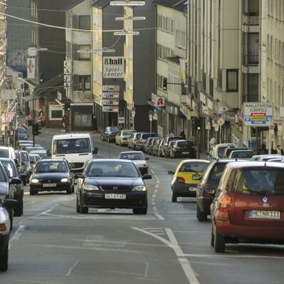 Autos auf mehrspuriger Straße in Häuserschlucht