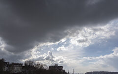 Dunkler Wolkenhimmel mit Stadt-Silhouette