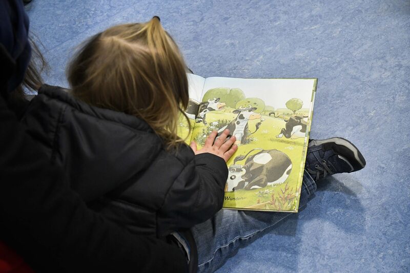 Ein Kind schuat ein Bilderbuch an.