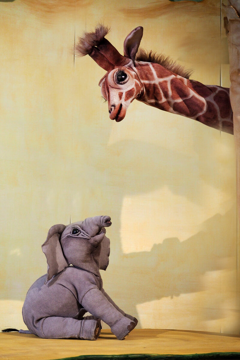 Das Elefantenkind aus dem Theaterstück im Gespräch mit einer Giraffe
