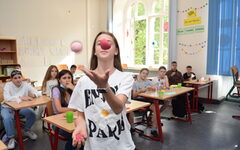Ein Mädchen jongliert mit Bällen, andere Schüler schauen zu