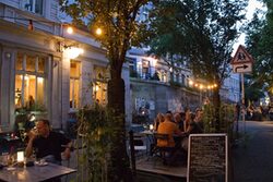 Außengastronomie in der Luisenstraße - Menschen an Tischen im Abendlicht