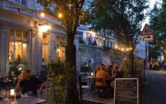 Außengastronomie in der Luisenstraße - Menschen an Tischen im Abendlicht