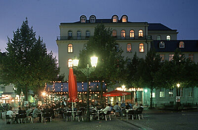 Abendstimmung auf dem Laurentiusplatz, Außengastronomie mit Beleuchtung und Gebäuden im Hintergrund