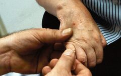 Zwei Hände halte eine Seniorenhand
