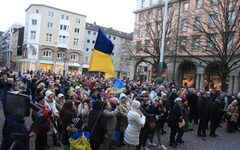 Viele Menschen mit blau-gelben Fahnen auf dem Johannes-Rau-Platz