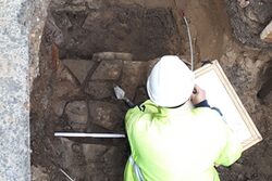 Ein Archäologe dokumentiert den Mauerfund.