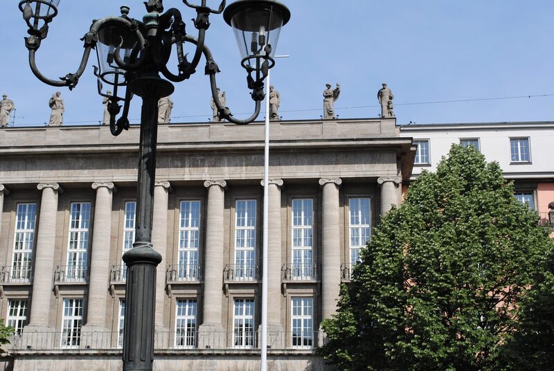 Rathausfassade mit Kandelaber im Vordergrund, Fenster des Ratssaales, Figuren auf dem Dach und Baum