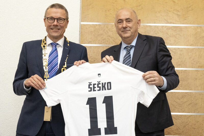 Oberbürgermeister Schneidewind bekommt vom Fußballverbandspräsidenten Radenko Mijatovic ein Trikot des Nationalspielers Šeško überreicht