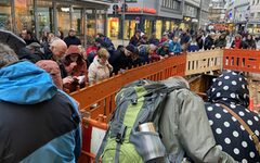 Teilnehmer der archäologischen Führung blicken in eine Baugrube.