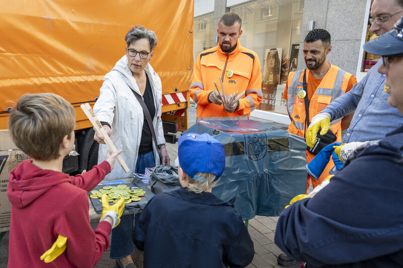 Das Team der ESW gibt Müllsäcke und Handschuhe an Kinder und Erwachsene aus