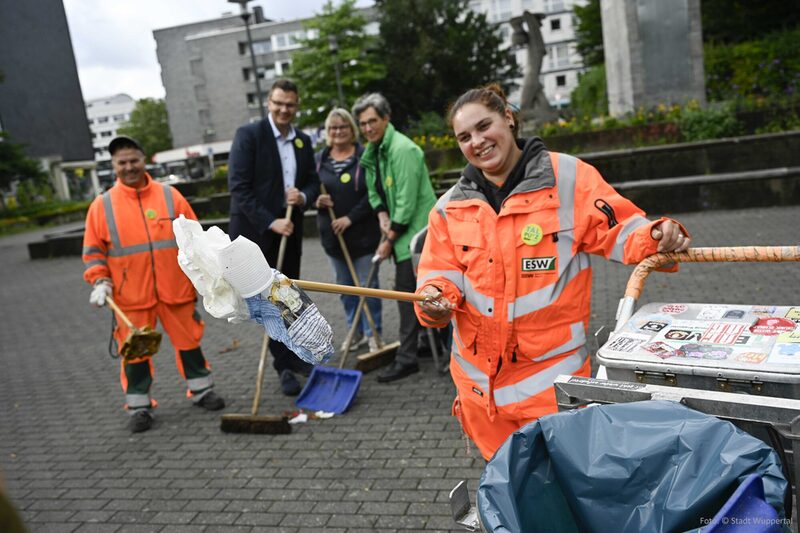 Kollegen vom ESW und vom Organisationsteam sammeln Müll im Deweerthschen Garten ein.